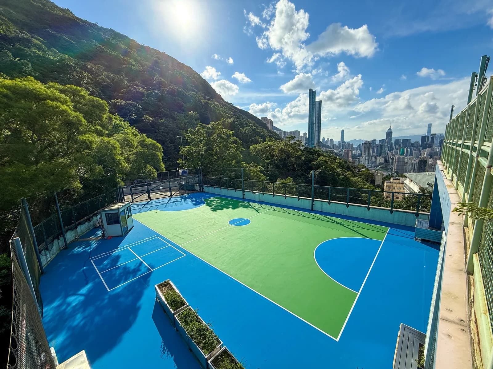 法国国际学校蓝塘道校区天台球场，背景是跑马地山景与港岛楼群