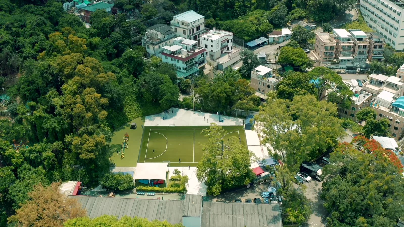 航拍挪威国际学校大埔锦山小学校园，绿树环绕的球场与校舍
