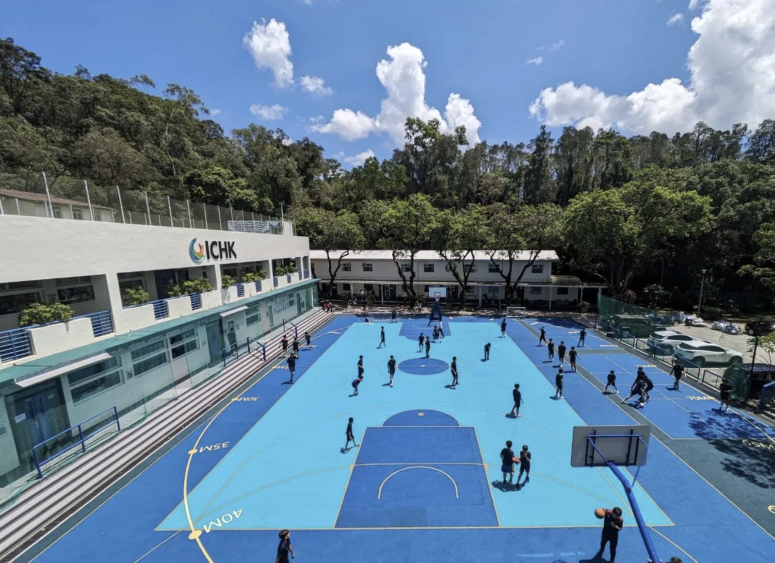 香港国际学院沙头角校园,教学楼旁的蓝色运动场与山林