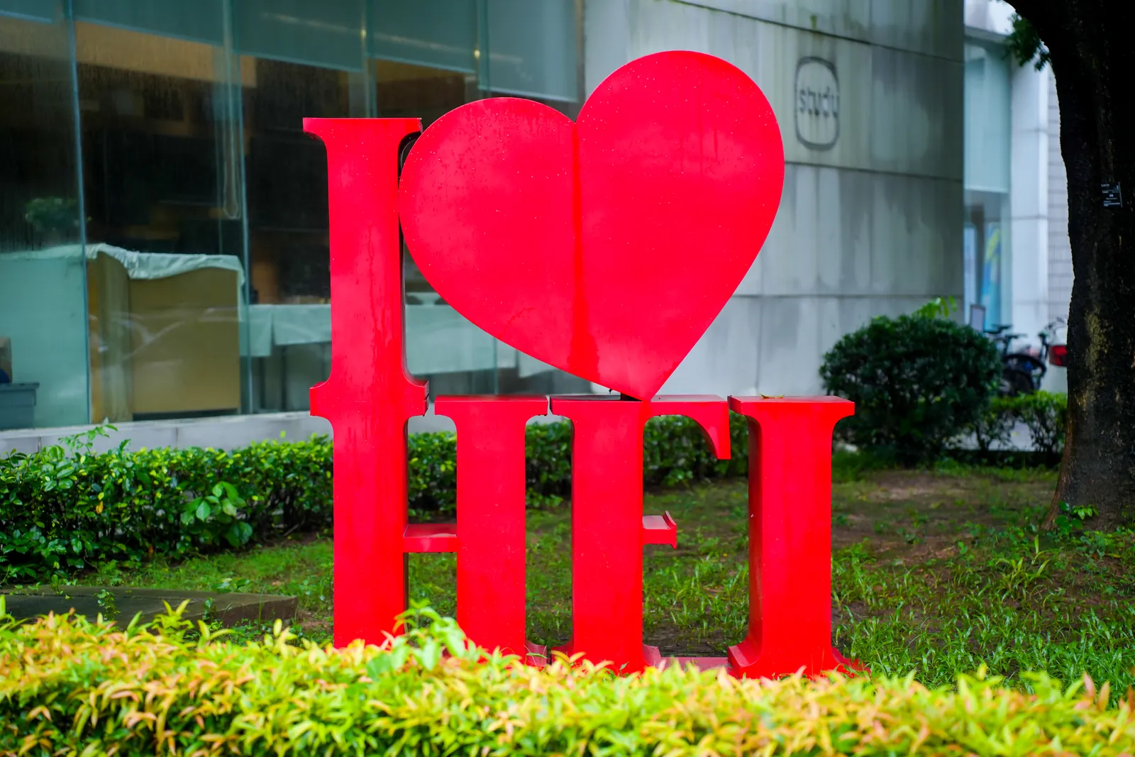 华附国际部校园草坪上的红色“I ♥ HFI”字母雕塑