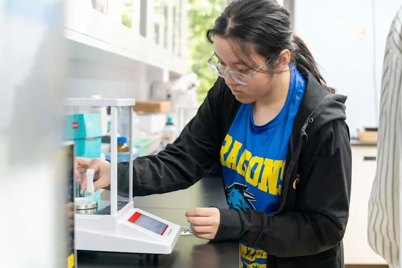 高中科学实验室里，学生用电子天平称量样品