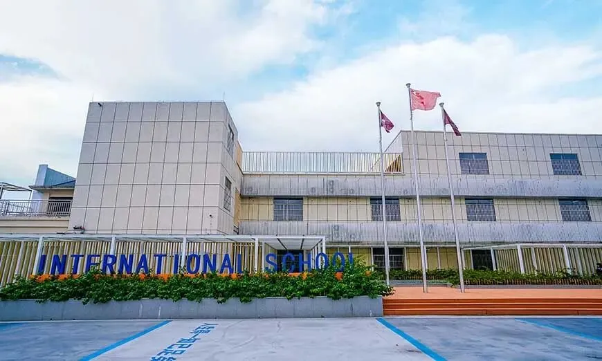 美中国际部教学楼外观,楼前有“INTERNATIONAL SCHOOL”字样和绿化带